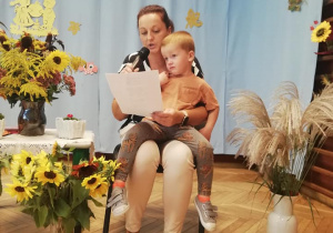 chłopiec na kolanach mamy czytającej wiersz