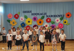 grupa dzieci na tle dekoracji w kwiaty