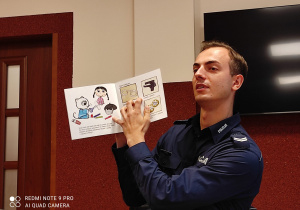 policjant z książką dla dzieci w ręku