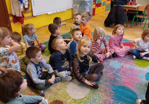 grupka dzieci siedząca na dywanie