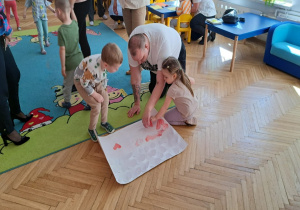 osoba dorosła, dziewczynka przykleja serduszko