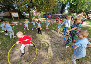 podwórko przedszkolne, przedszkolaki, nauczycielki, zabawa z hula-hoop