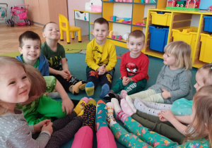 przedszkolaki siedzące w kole w kolorowych skarpetkach