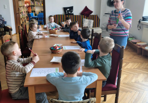 sala biblioteczna, pani bibliotekarka, przedszkolaki przy stolikach