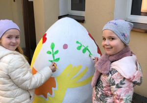 2 dziewczynki malujące duże wielaknocne jajo
