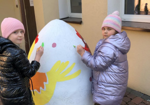 2 dziewczynki malujące duże wielaknocne jajo