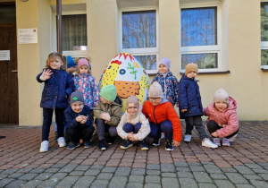 grupka przedszkolaków, duże wielkanocne jajo