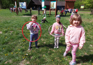 przedszkolaki bawiące sie w lesie z hula-hoop