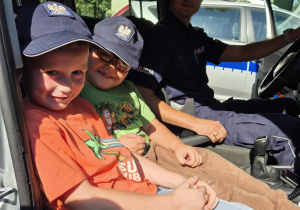 policjant, przedszkolaki w radiowozie