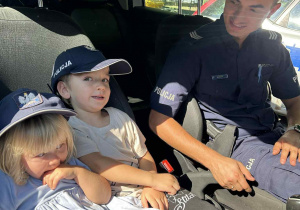 policjant, przedszkolaki w radiowozie