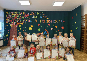 grupa przedszkolaków z prezentami, jesienne tło